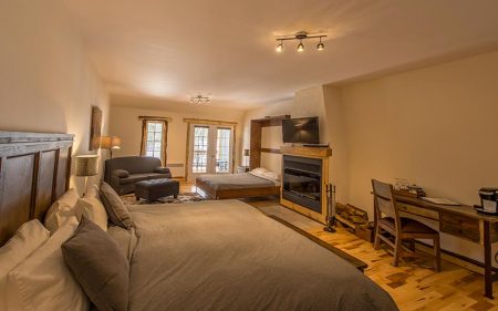 Luxurious room with a king size bed and wood fireplace  - Auberge du Vieux Moulin